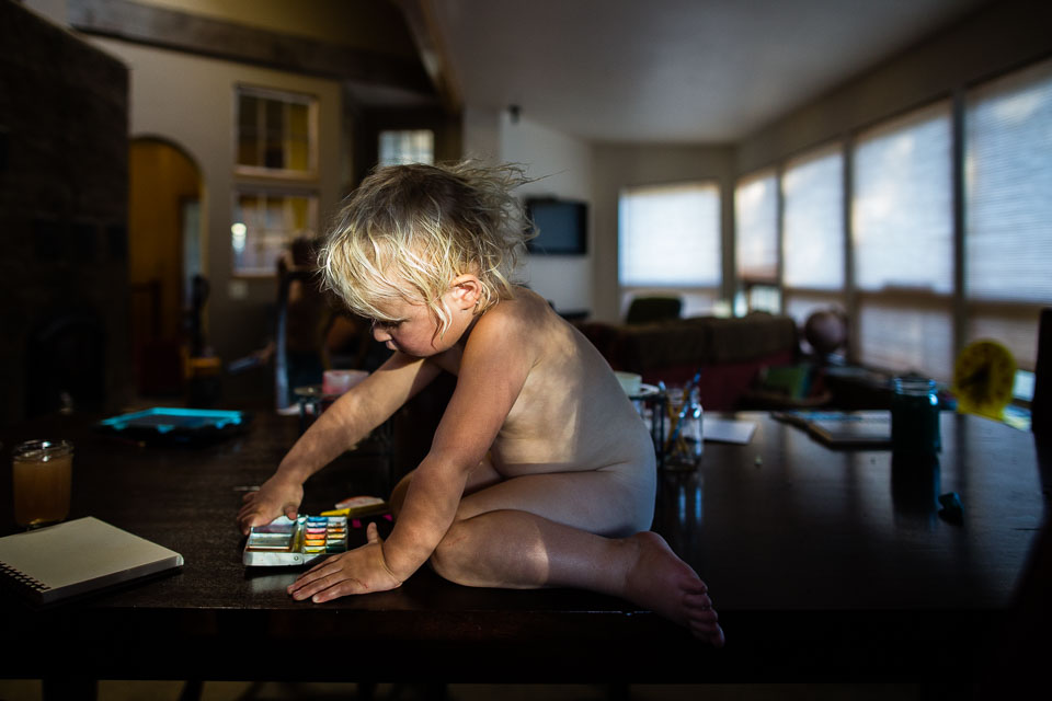bare child with markers on top of table