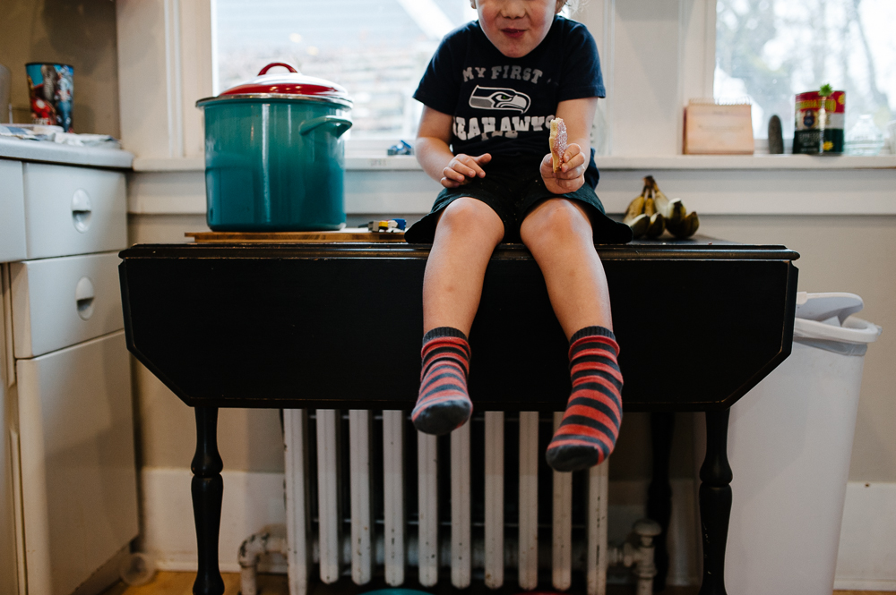 boy counting on fingers sitting on counter -Documentary Family Photography