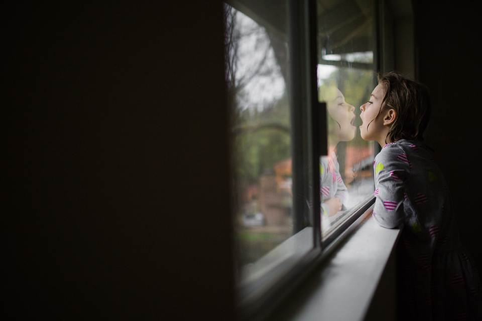 girl breathing on window - Documentary Family Photography