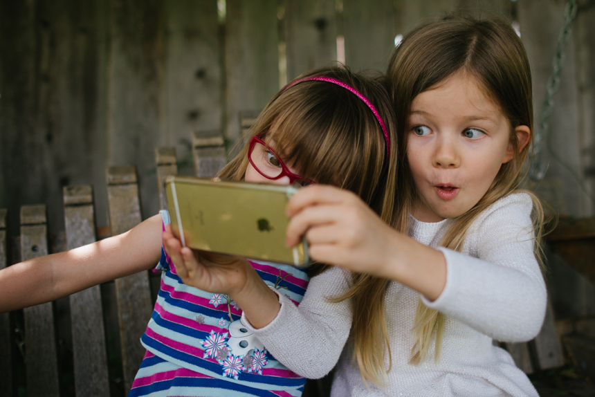 girls play on smartphone - Documentary Family Photography