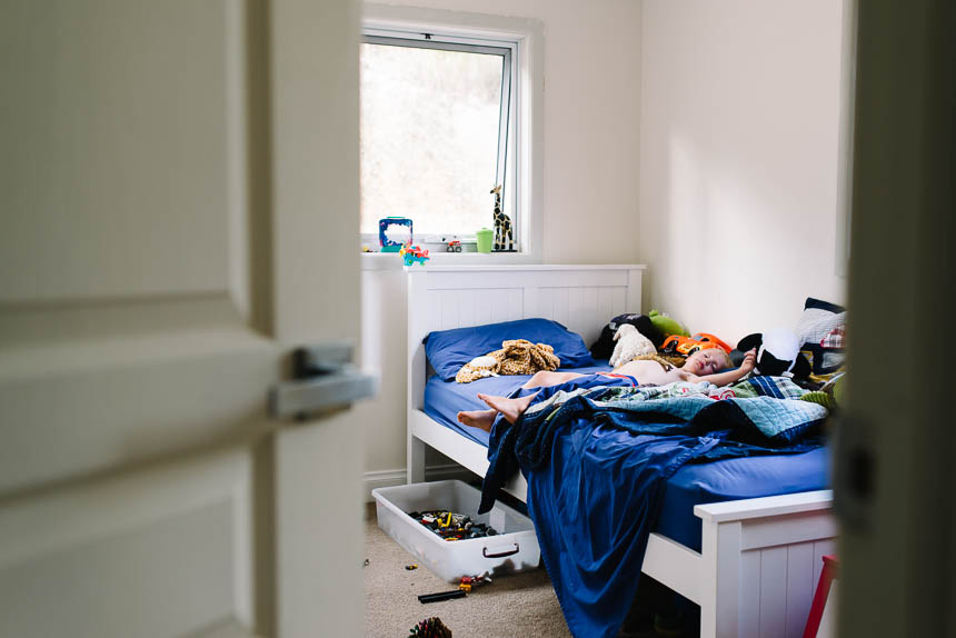 boy on bed in messy room - Documentary Family Photograpy