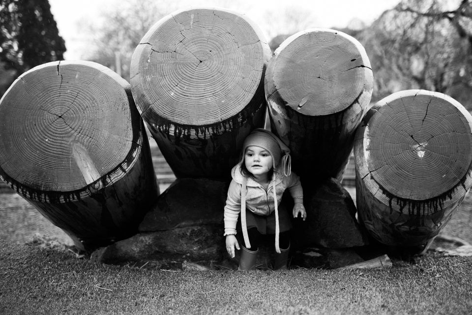 girl hiding under logs - Documentary Family Photography