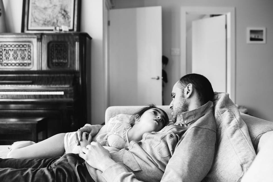 girl cuddles with father - Documentary Family Photography