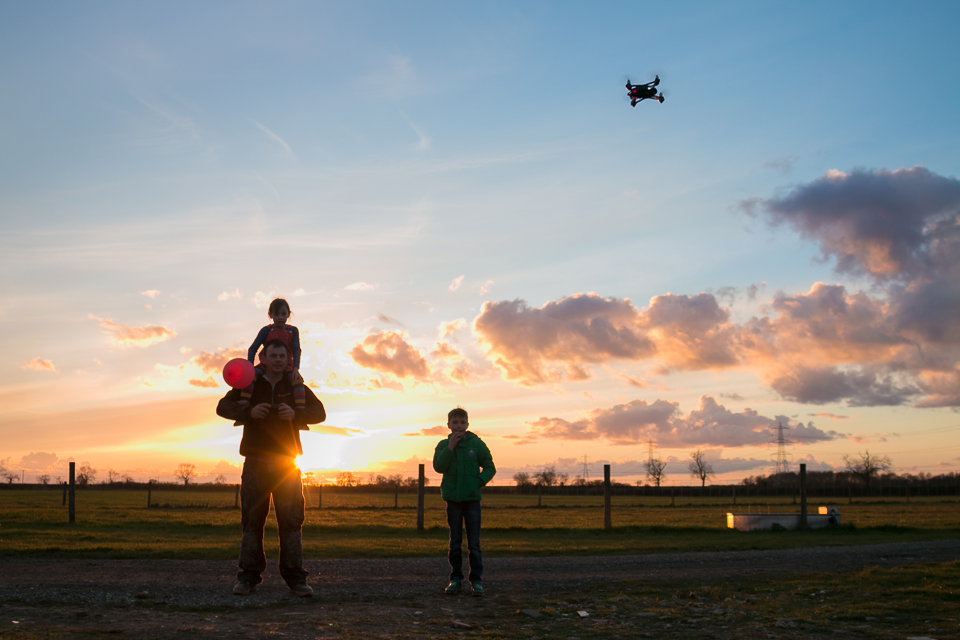 kids and father play with drone at sunset - documentary family photography