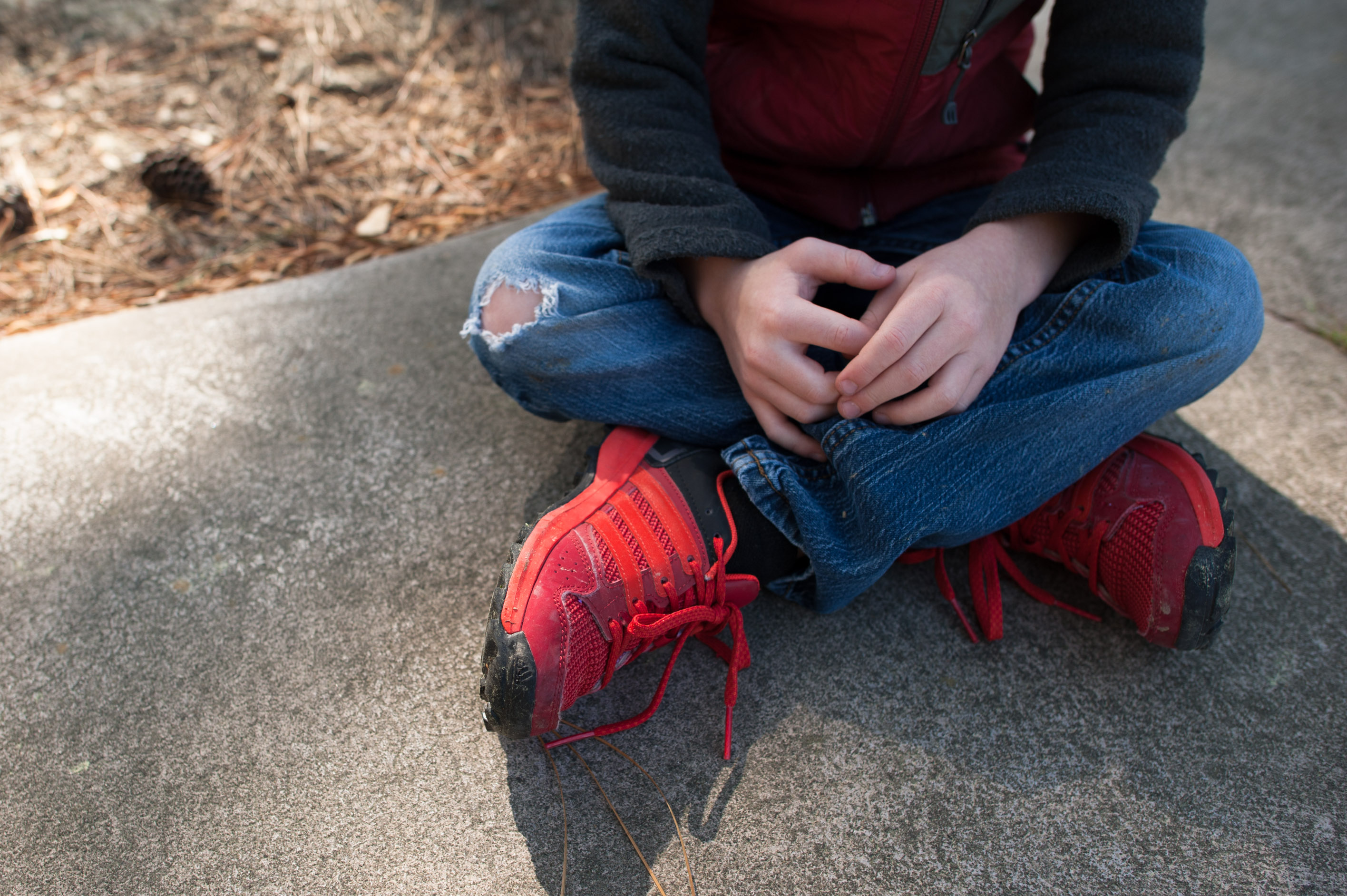 boy sits with legs crossed - documentary family photography