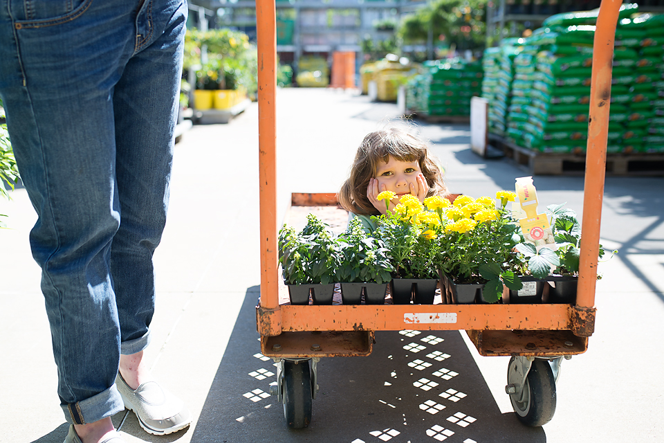 little girl on flower cart - Documentary Family Photography