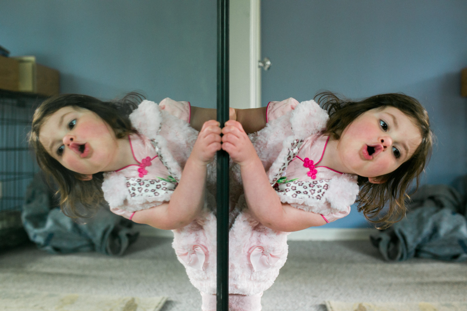 Girl playing with mirrored door - Documentary Family Photography