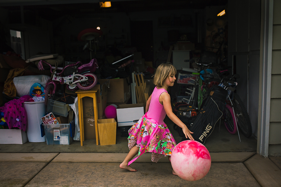 girl with large ball in garage - Documentary Family Photography