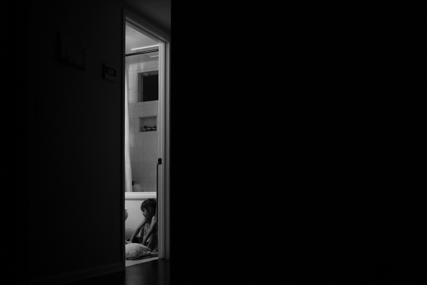 child in bathroom through doorway - Documentary Family Photography