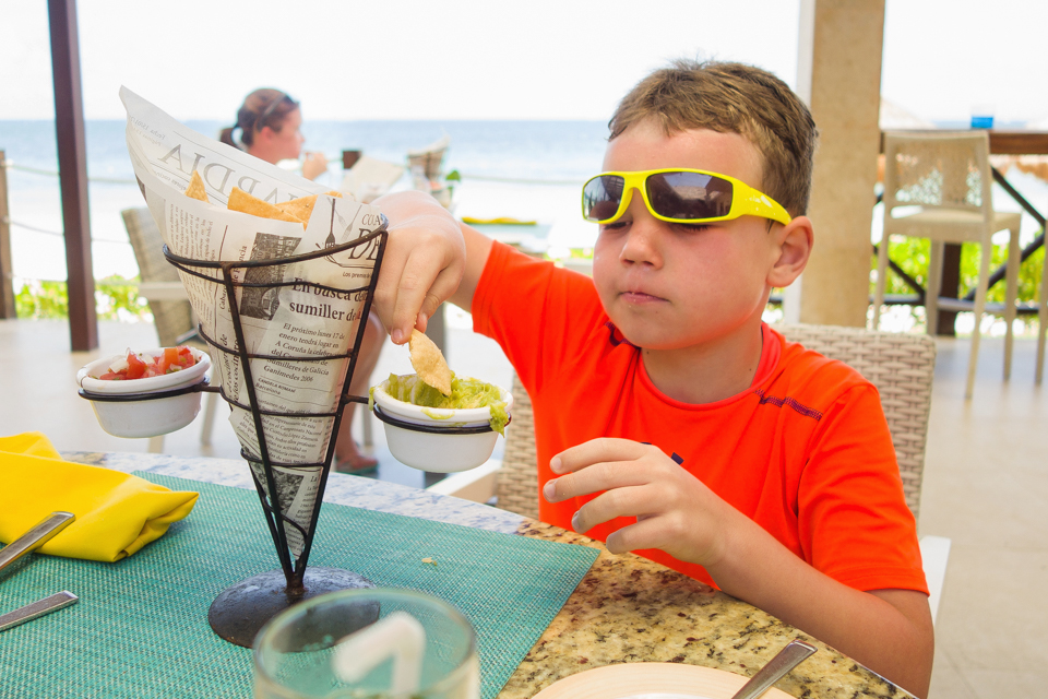 boy eating fries with while wearing sunglasses - Documentary Family Photography