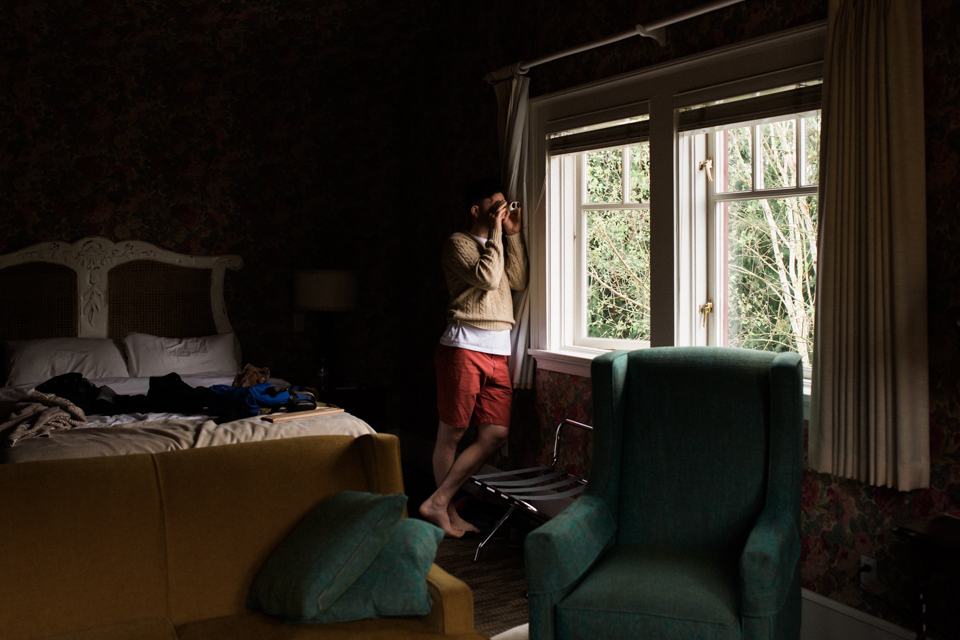 man with binoculars at window -Documentary Family Photography