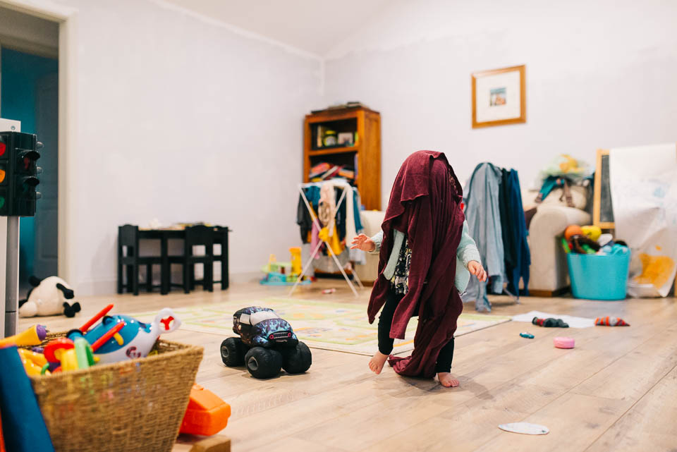 child playing in laundry - Documentary Family Photography