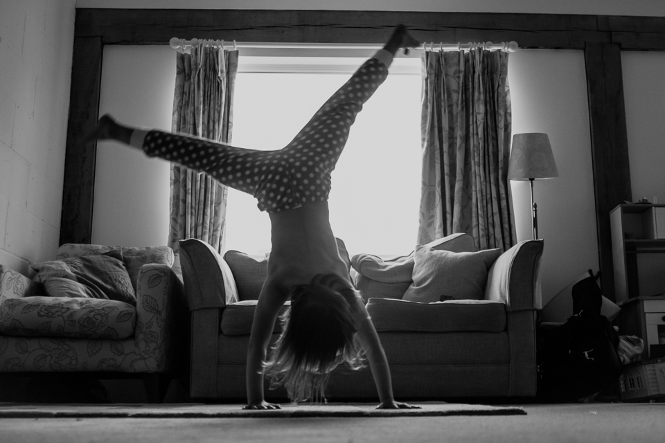 girl doing cartwheel in house - Documentary Family Photography