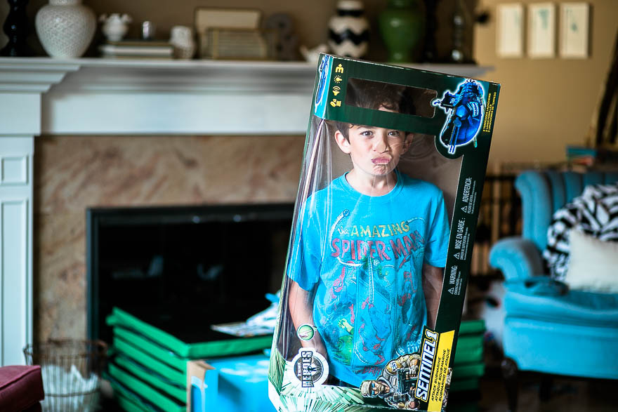 Boy in toy packaging - Documentary Family Photography