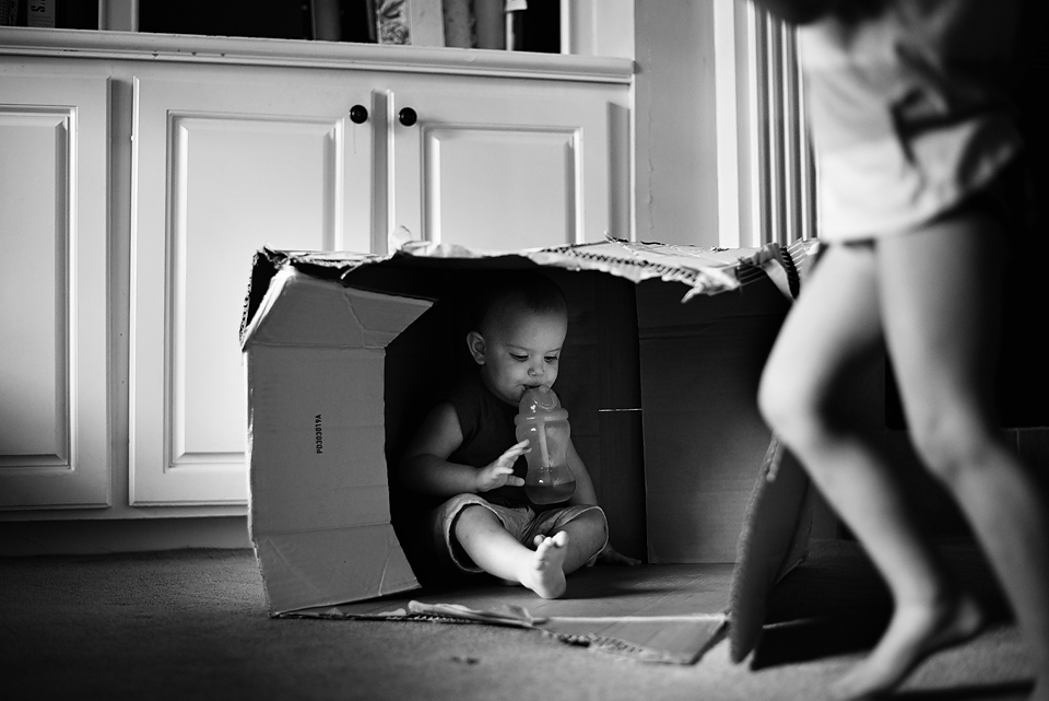 Boy plays in cardboard box - Documentary Family Photography