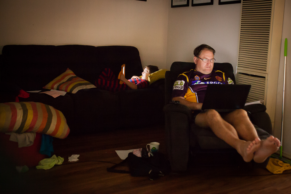Father and son lounge with electronics - Documentary Family Photography