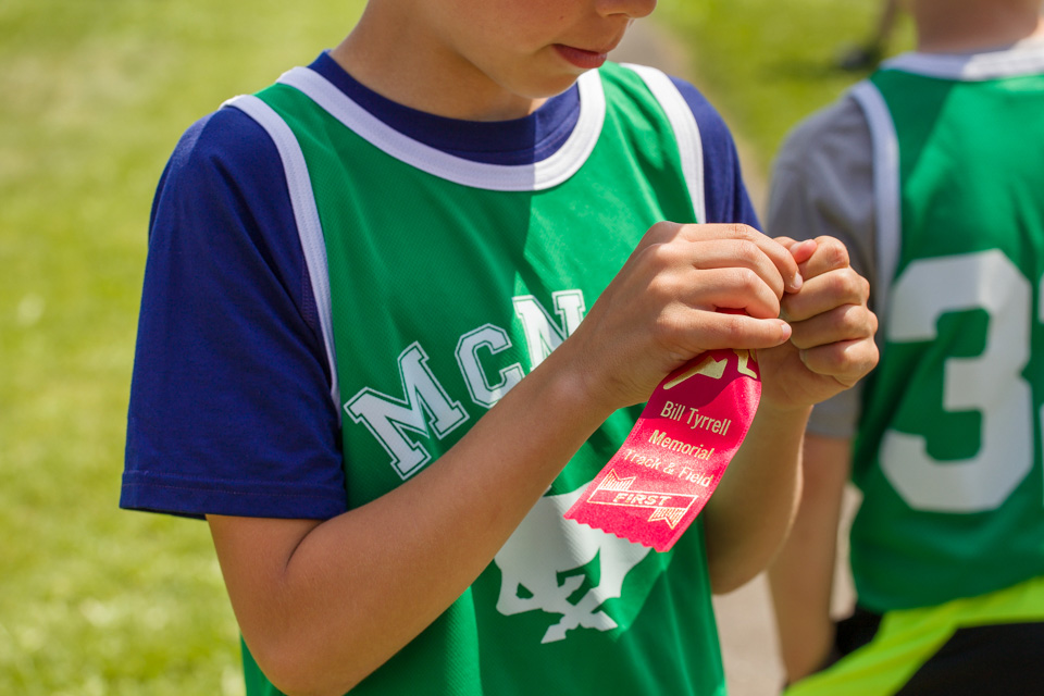 boy wins track ribbon - Documentary Family Photography