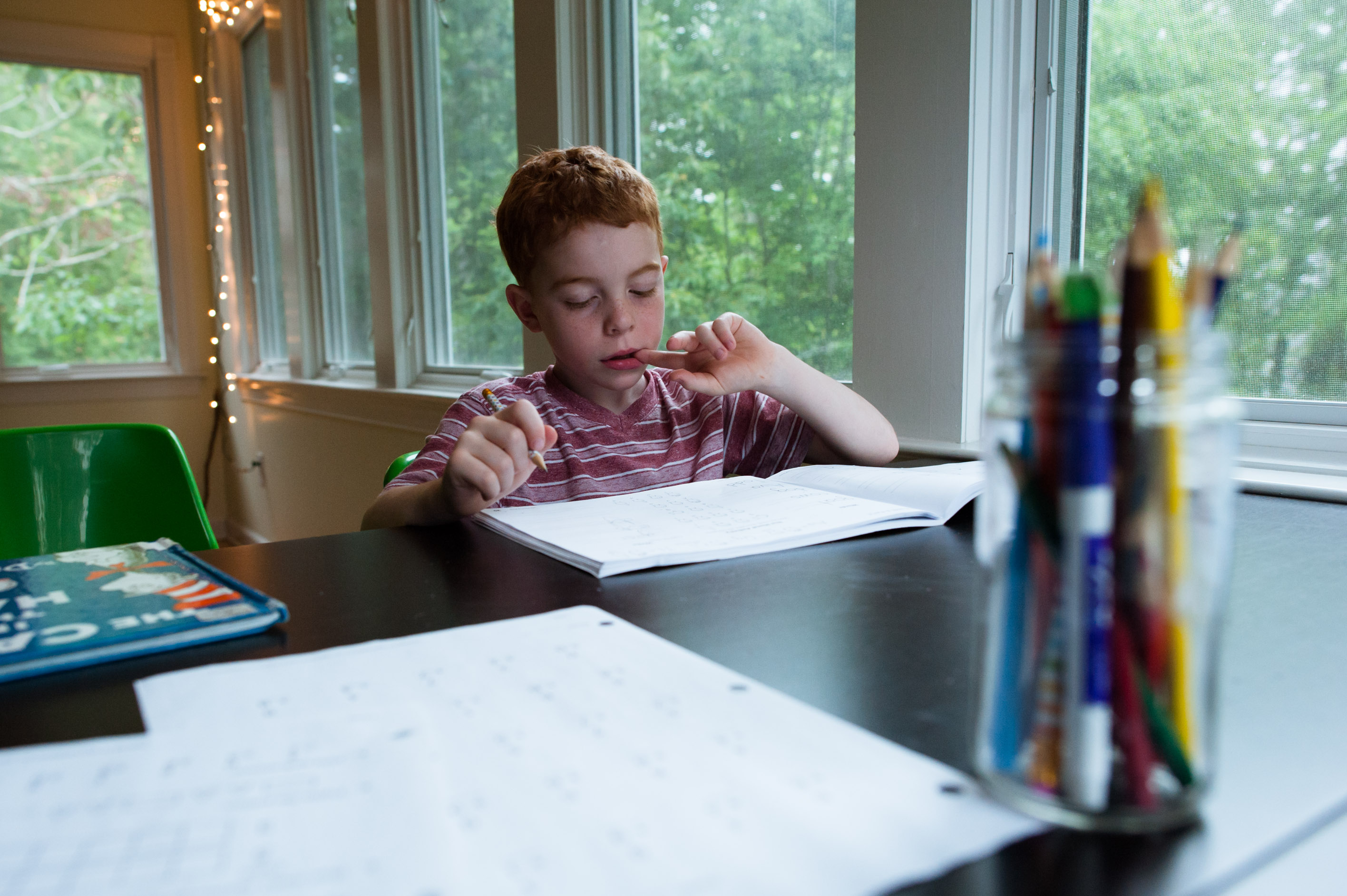 boy does schoolwork - Documentary Family PhotographyDocumentary Family Photography