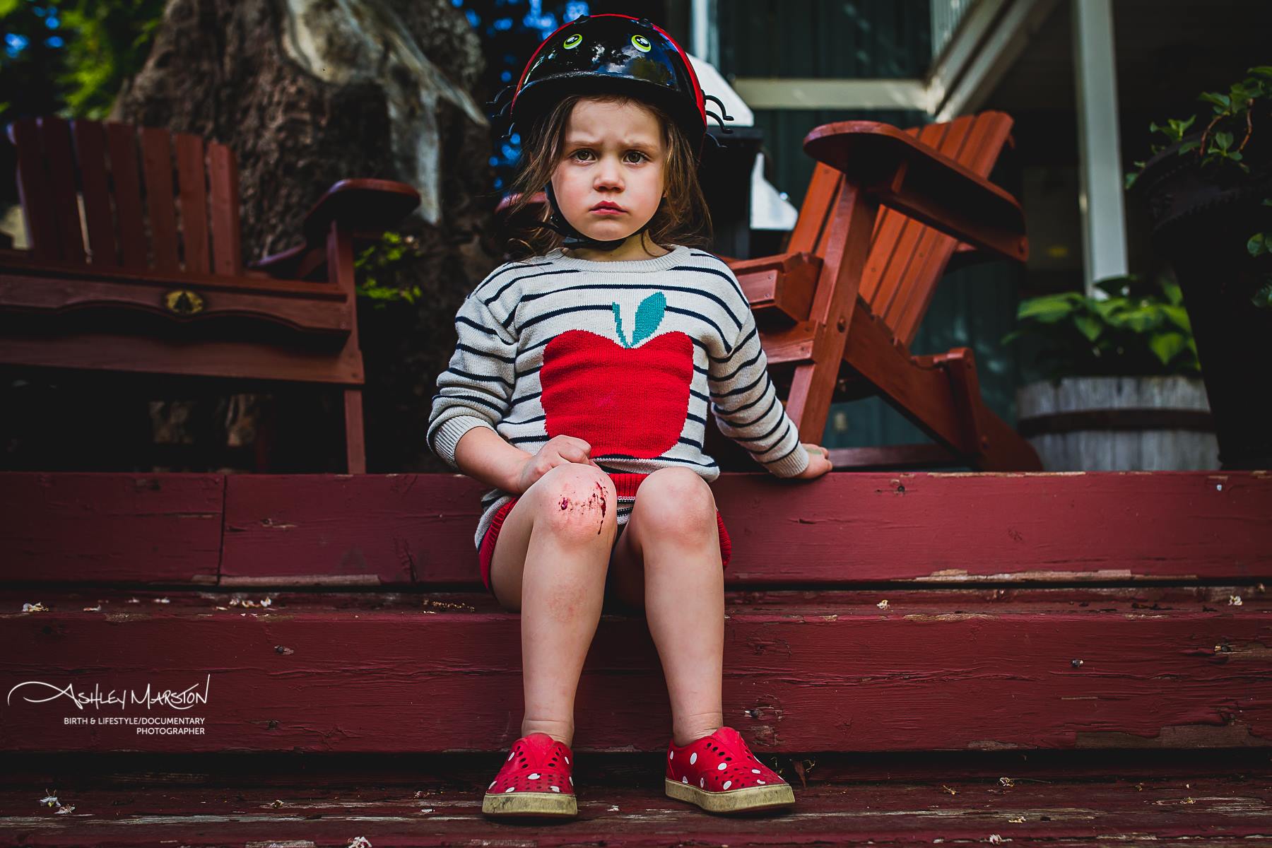 Girl sits on steps with grouchy face - Documentary Family Photography