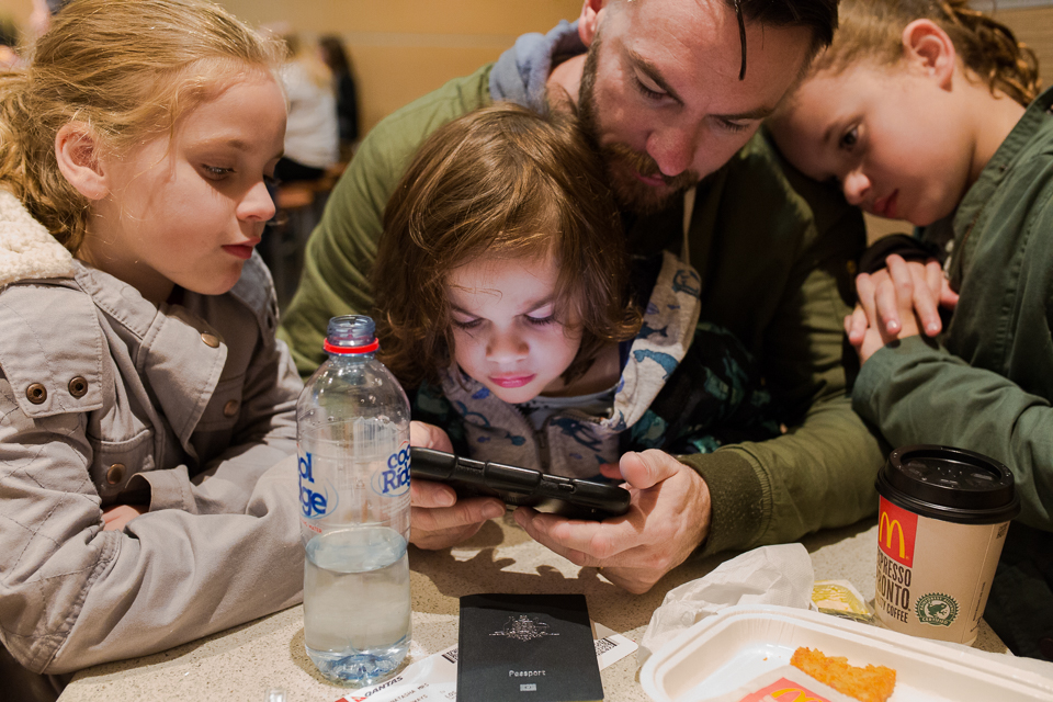 family huddled around phone - Documentary Family Photography