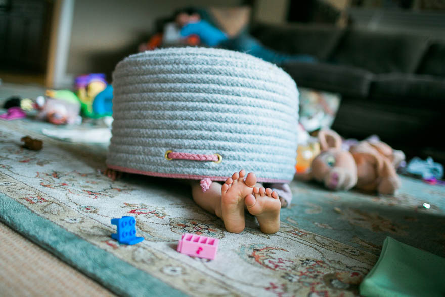 girl hiding under basket - Documentary Family Photography