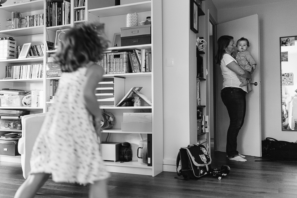 mom holds baby while girl watches on - documentary family photography