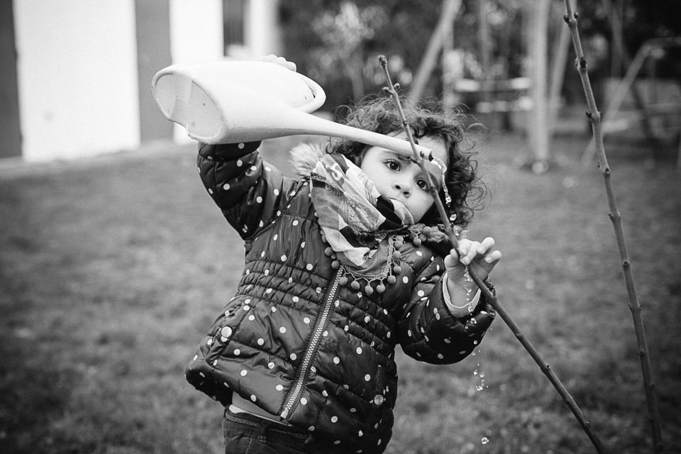 girl waters plants - documentary family photography