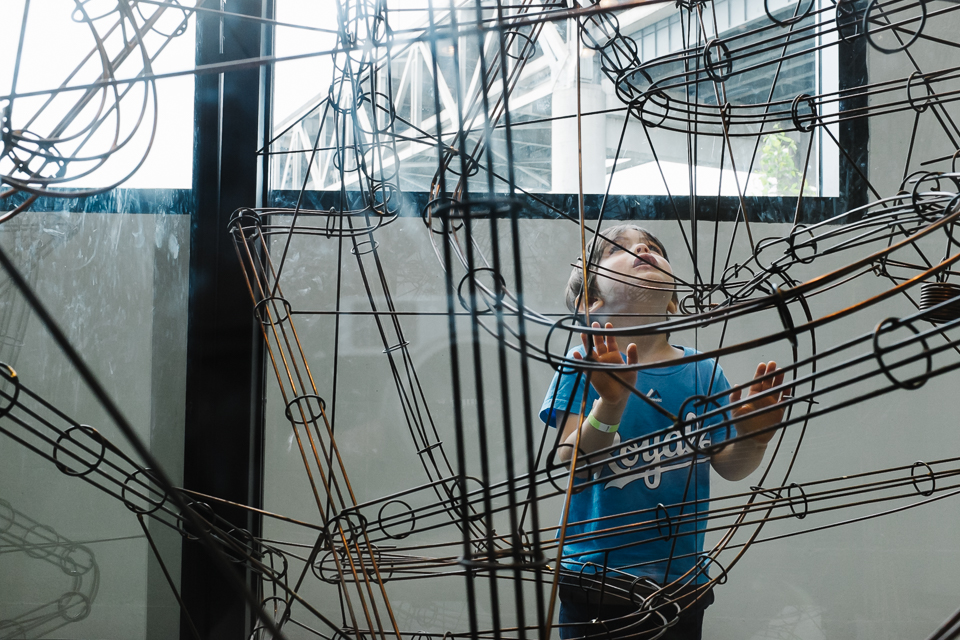 boy examines marble maze - Documentary Family Photography