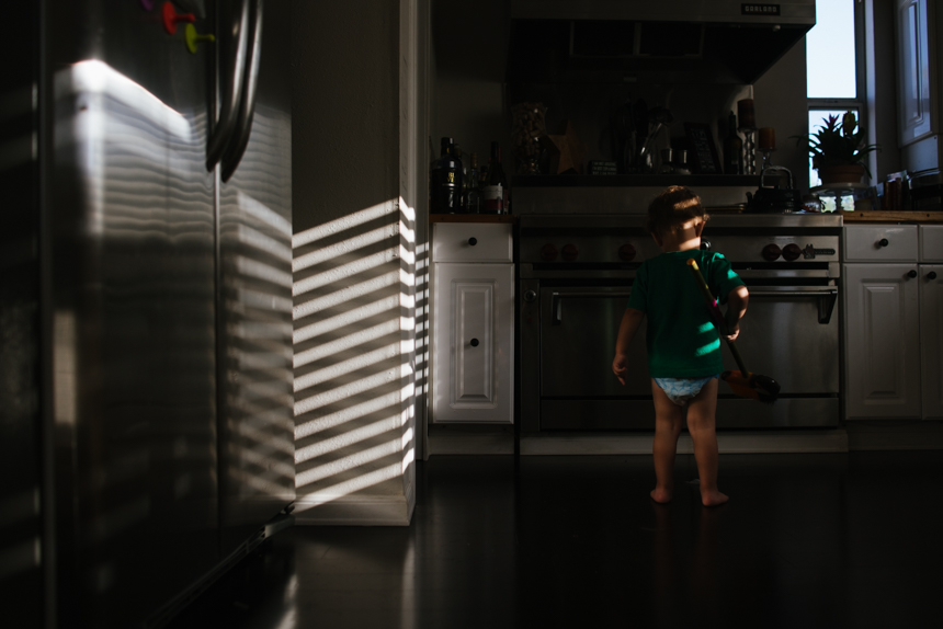 child in mini blind light - Documentary Family Photography