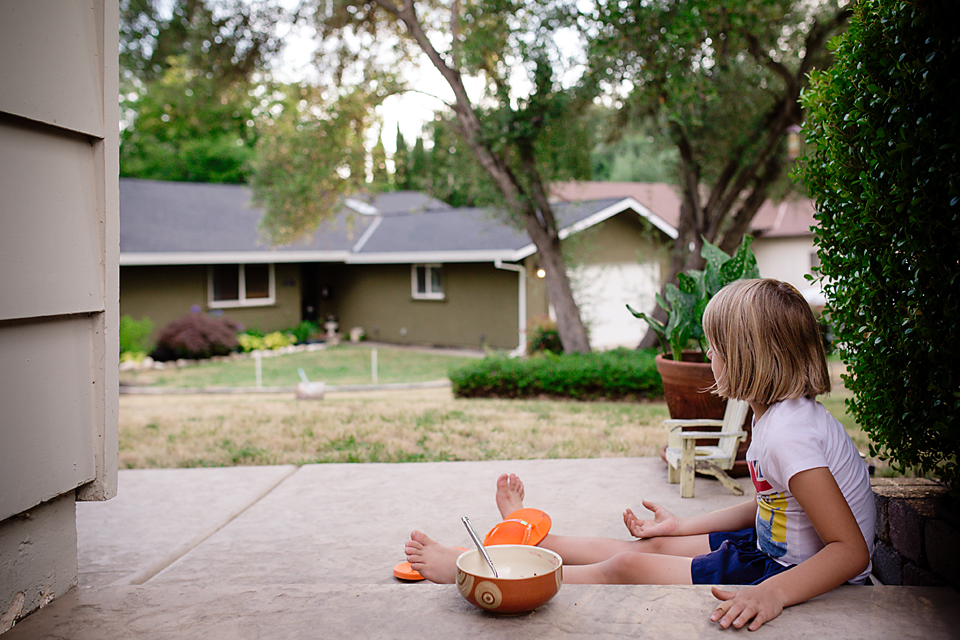 girl eats on front steps - Documentary Family Photography