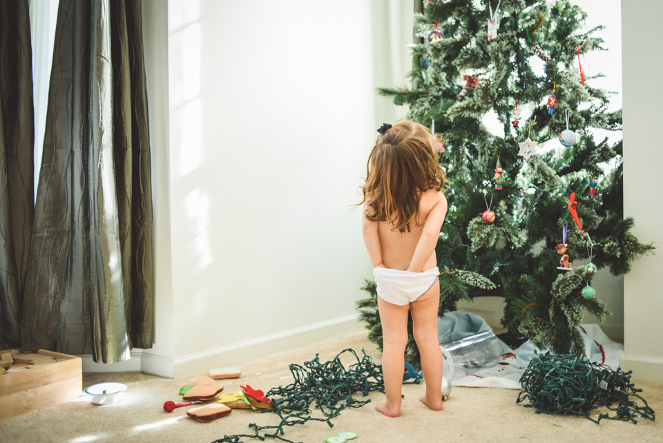 girl stares at undecorated Christmas tree - Documentary Family Photography