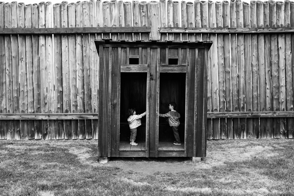 Kids in replica outhouse - Documentary Family Photography