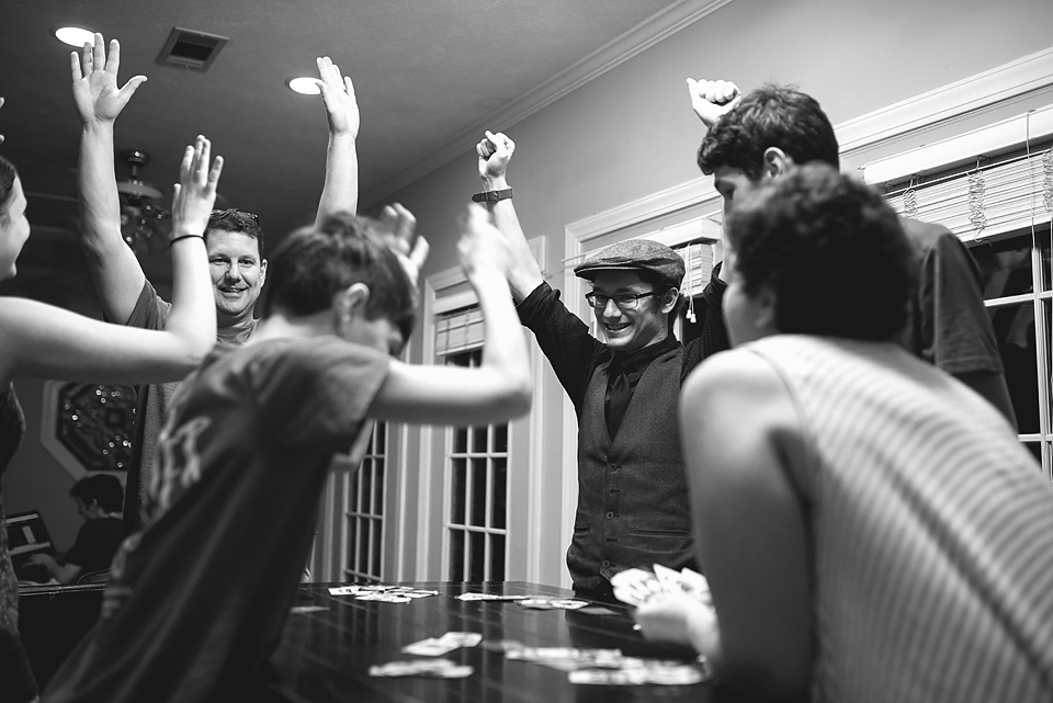 family plays cards at dinner table - Documentary Family Photography