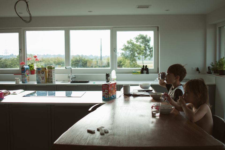 boy eats cereal at kitchen counter -Documentary Family Photography