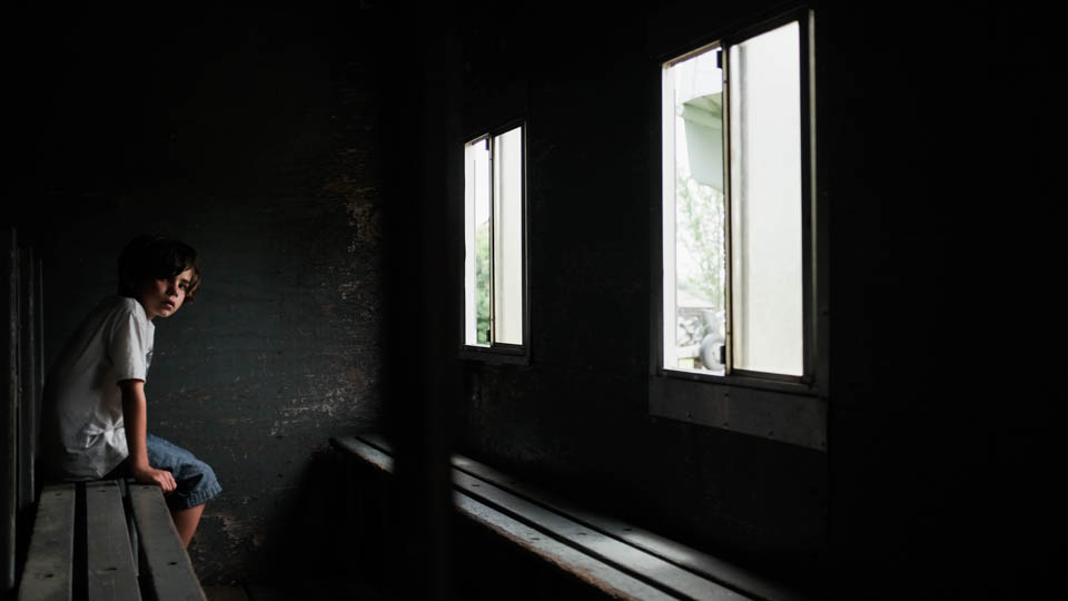 boy stares out window - Documentary Family Photography