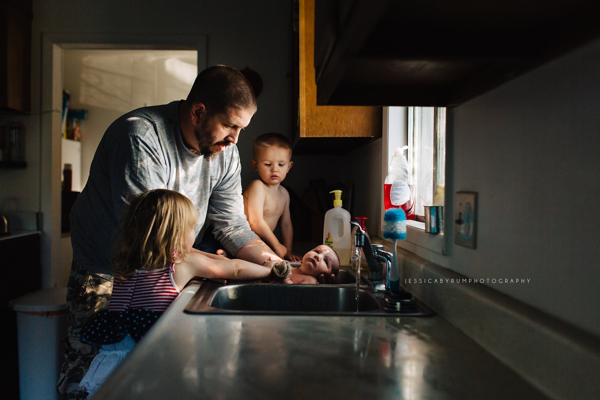 family gives baby sink bath - Documentary Family Photography