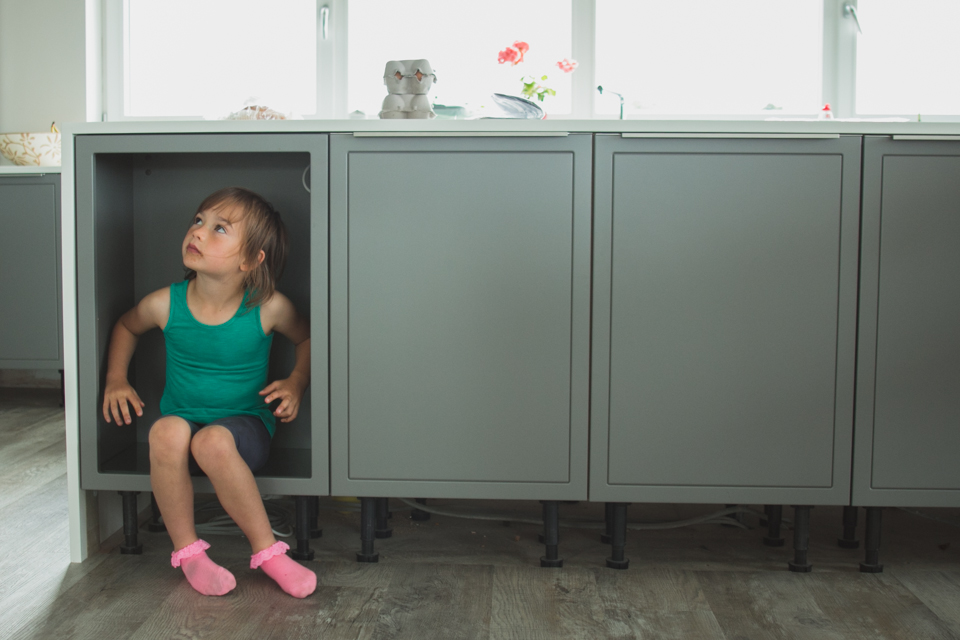 girl hiding in cabinet - Documentary Family Photography