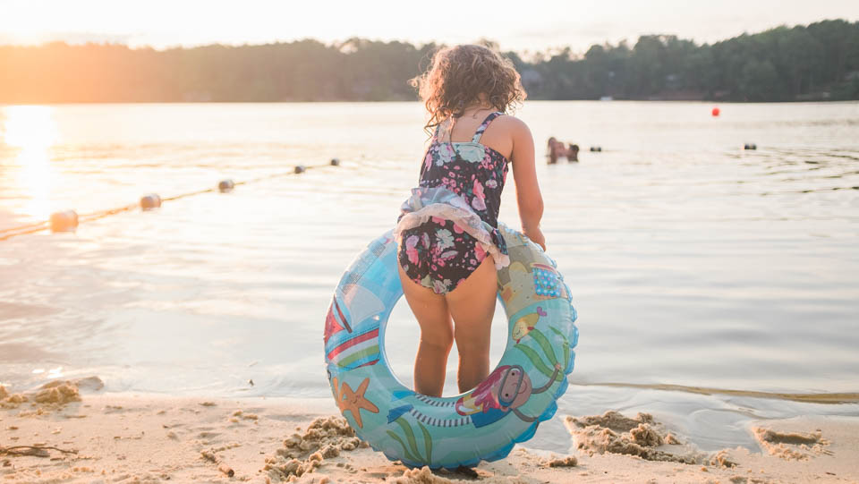 girl on beach with float toy - Documentary Family Photography