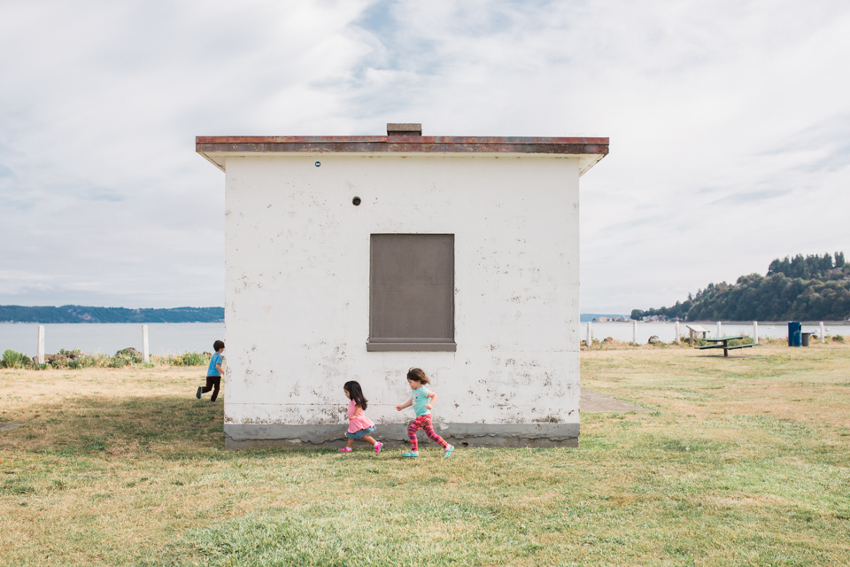 kids chasing each other around out building - Documentary Family Photography