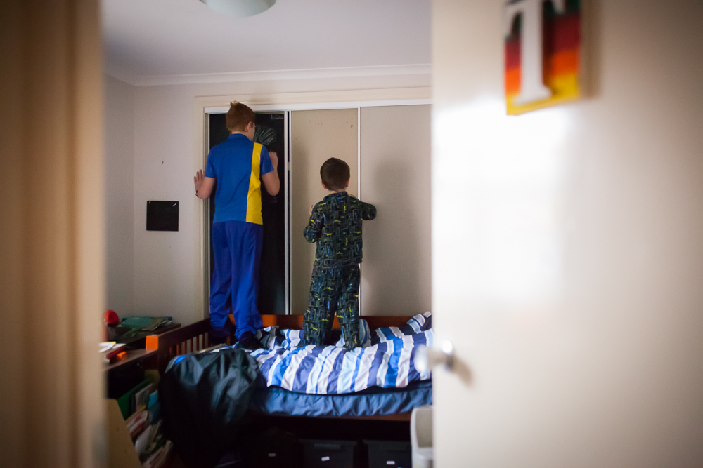 kids standing on bed looking in closet - Documentary Family Photography