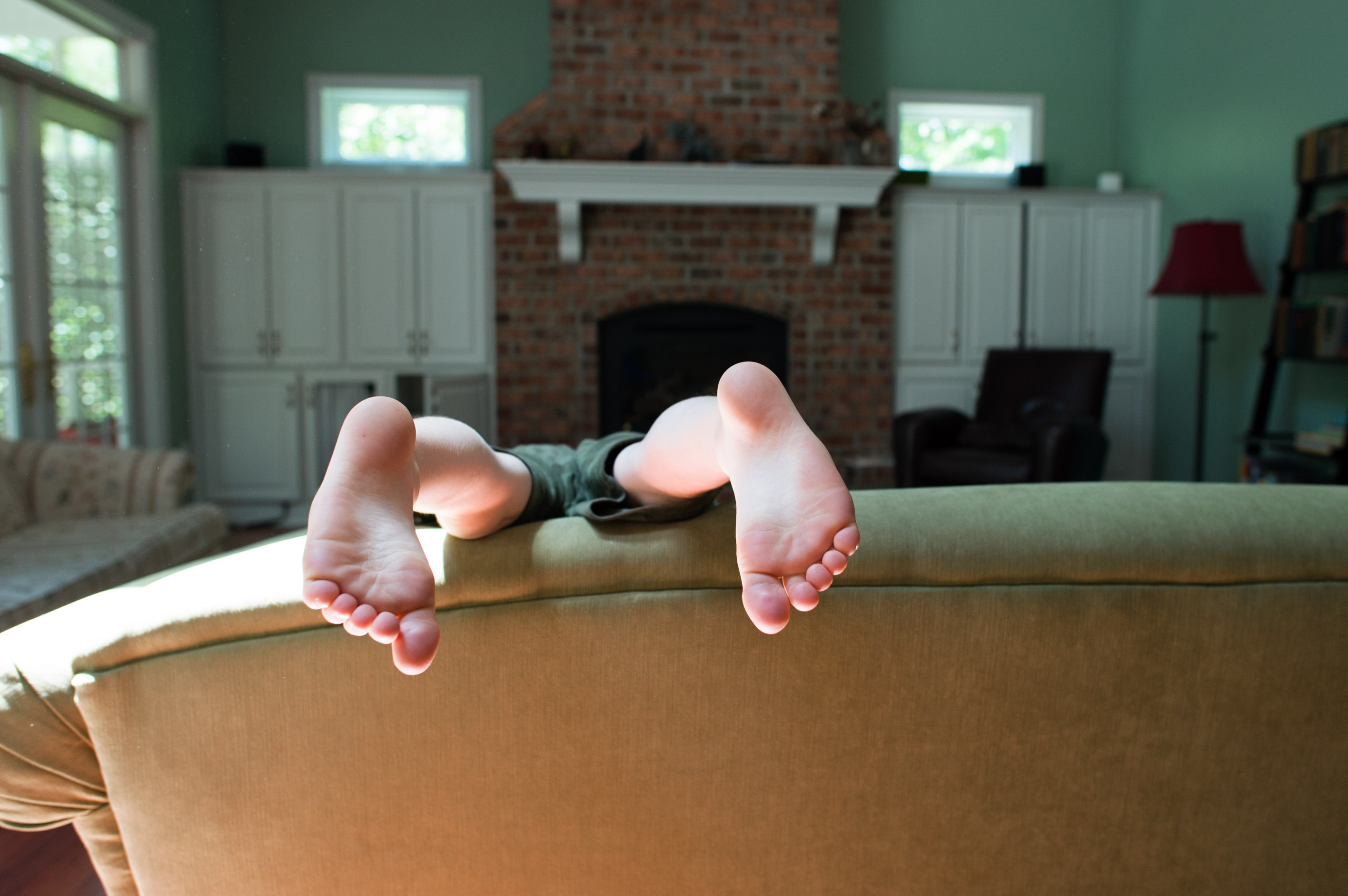 child's feet over couch - Documentary Family Photography