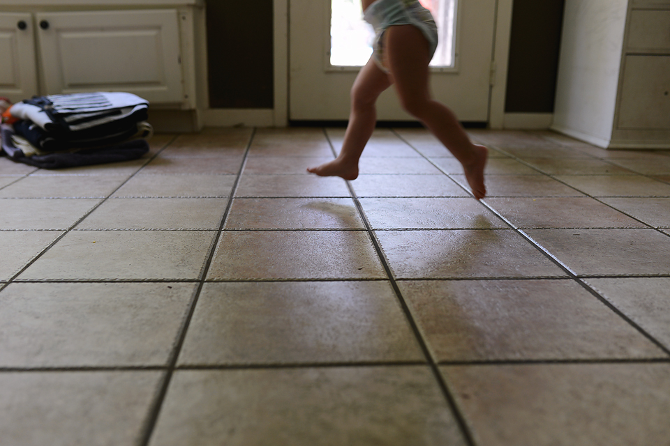 Baby runs across floor - Documentary Family Photography