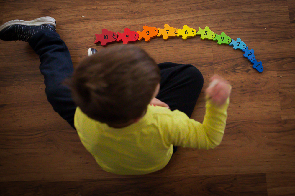 child with rainbow toy - Documentary Family Photography