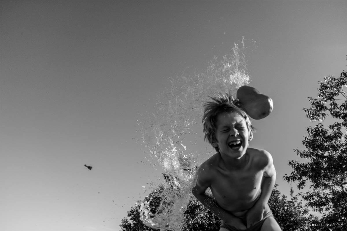 child hit by water balloon - Documentary Family Photography