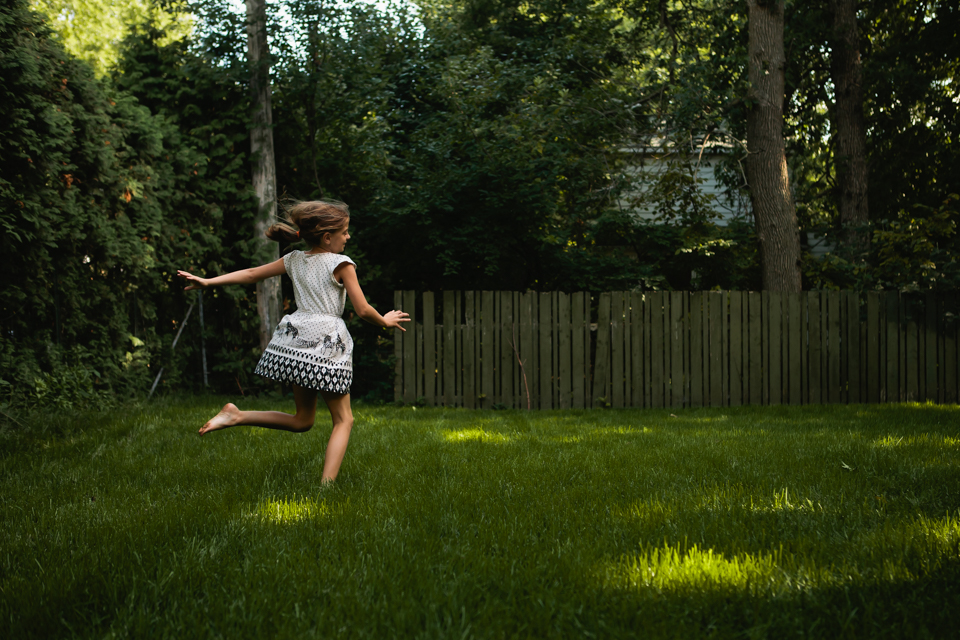 girl runs through backyard - Documentary Family Photography