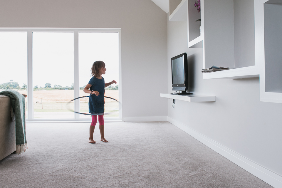 Girl hula hoops in house - Documentary Family Photography