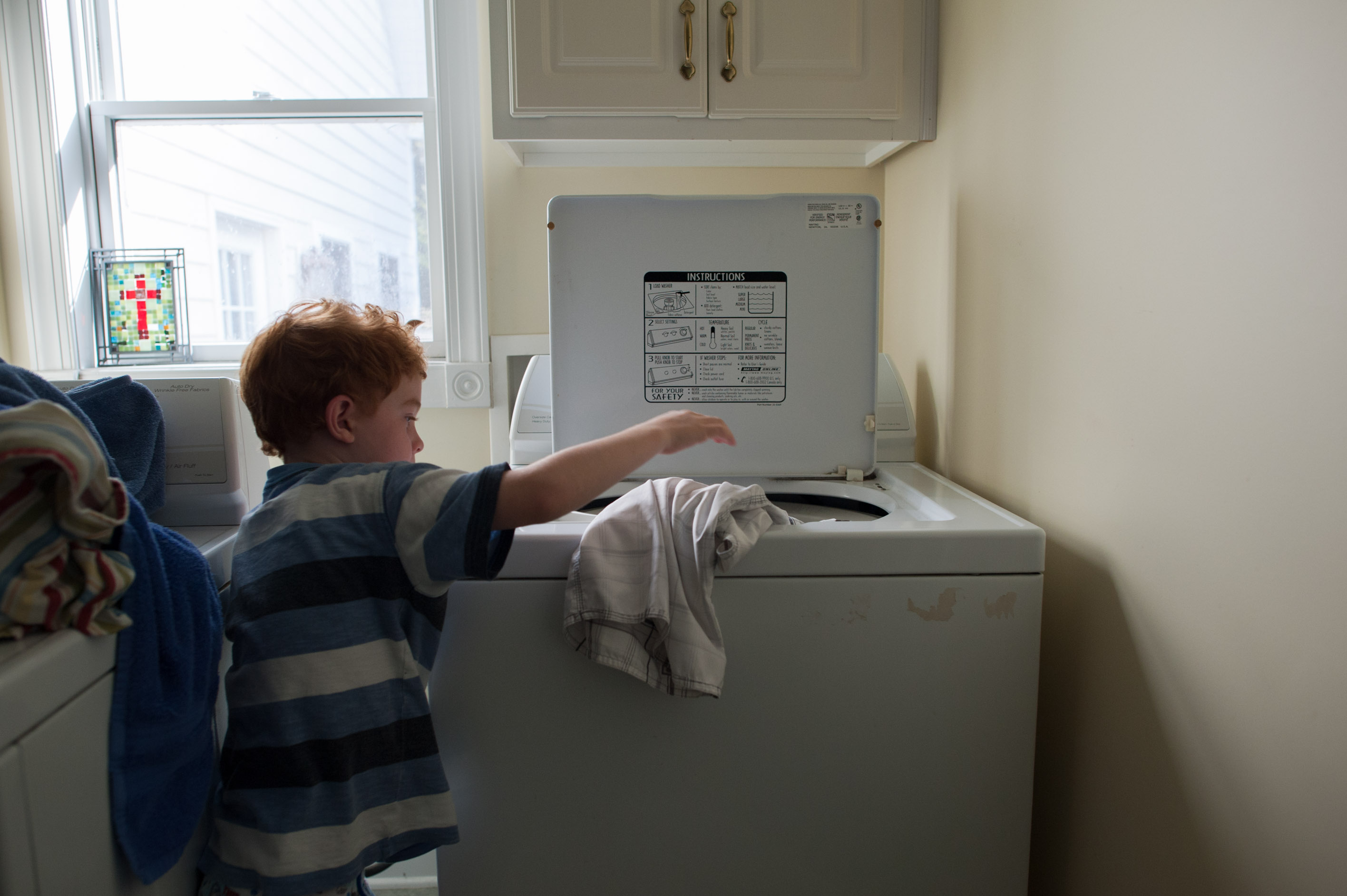boy does laundry - Documentary Family Photography