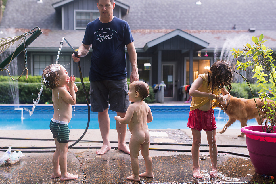 kids rinse in hose near pool -Documentary Family Photography