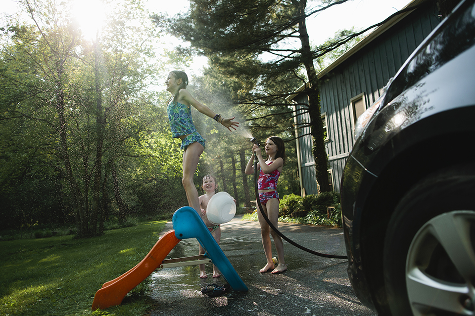 kids playing in hose on child's slide