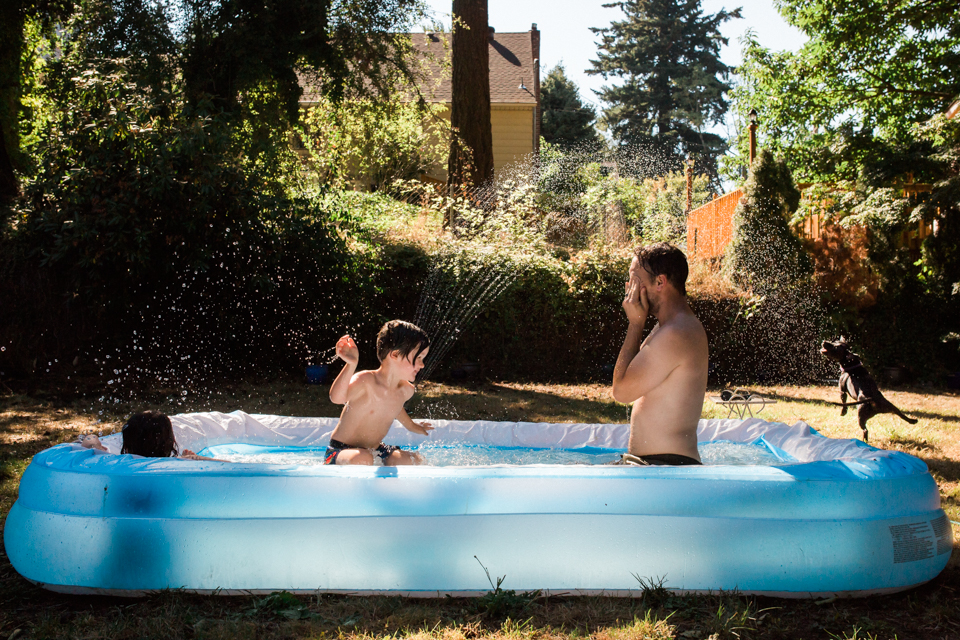 Father and son play in wading pool - Documentary Family Photography